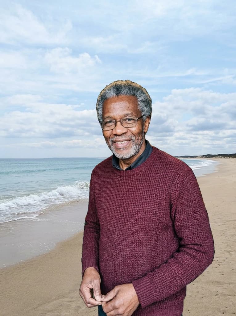 Man in a burgundy jumper, now standing on the beach from the reference background photo